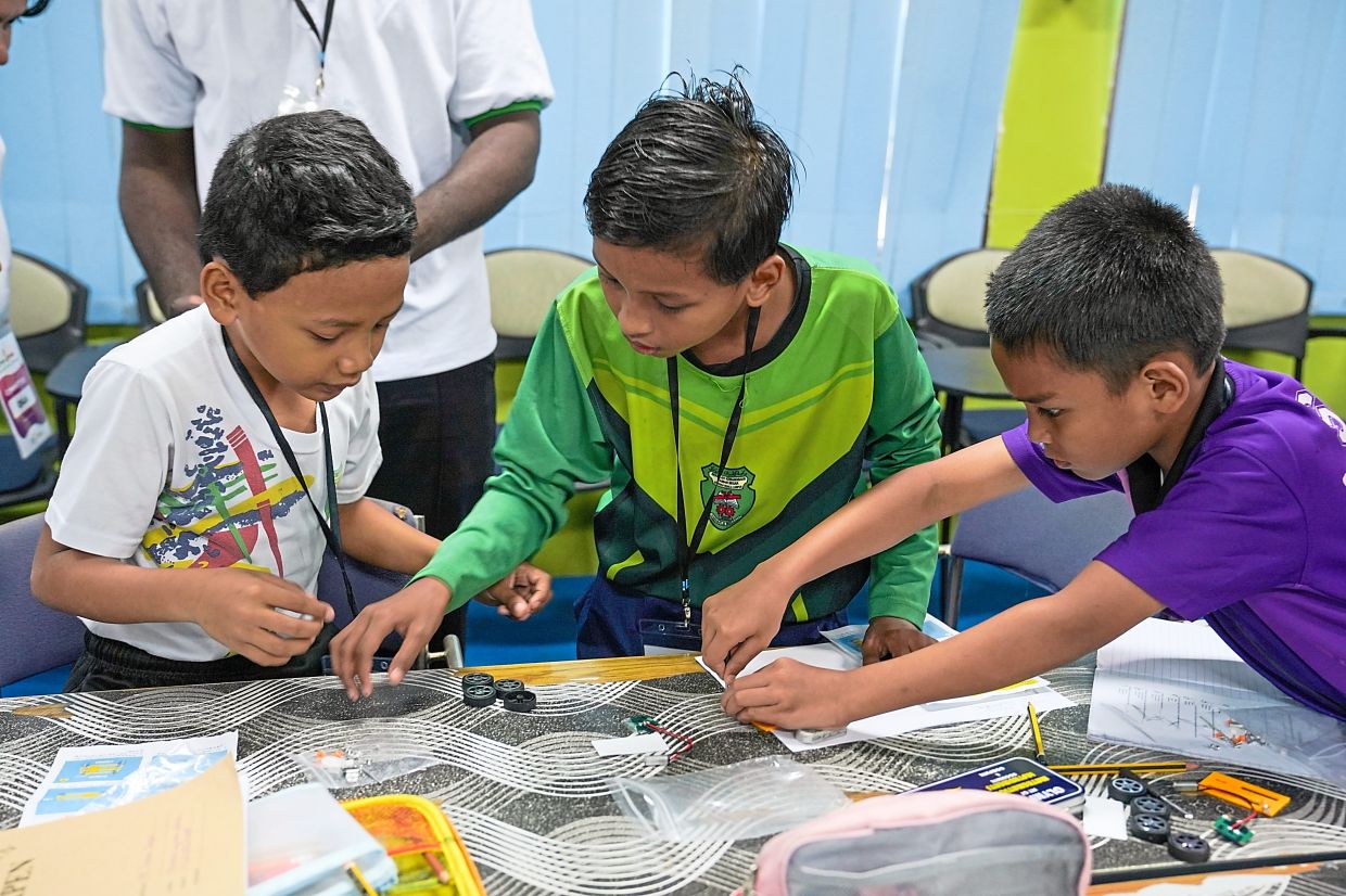 Enthusiastic pupils from SK Taman Segar learn the art of constructing a solar-powered car.